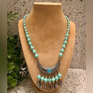 Blue swirl bead necklace with silver tone pendant.